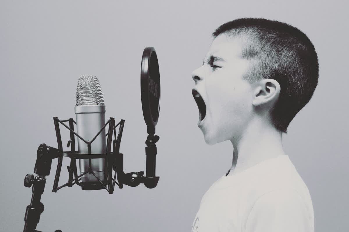 Enfant chantant devant un micro, apprendre l anglais en chanson